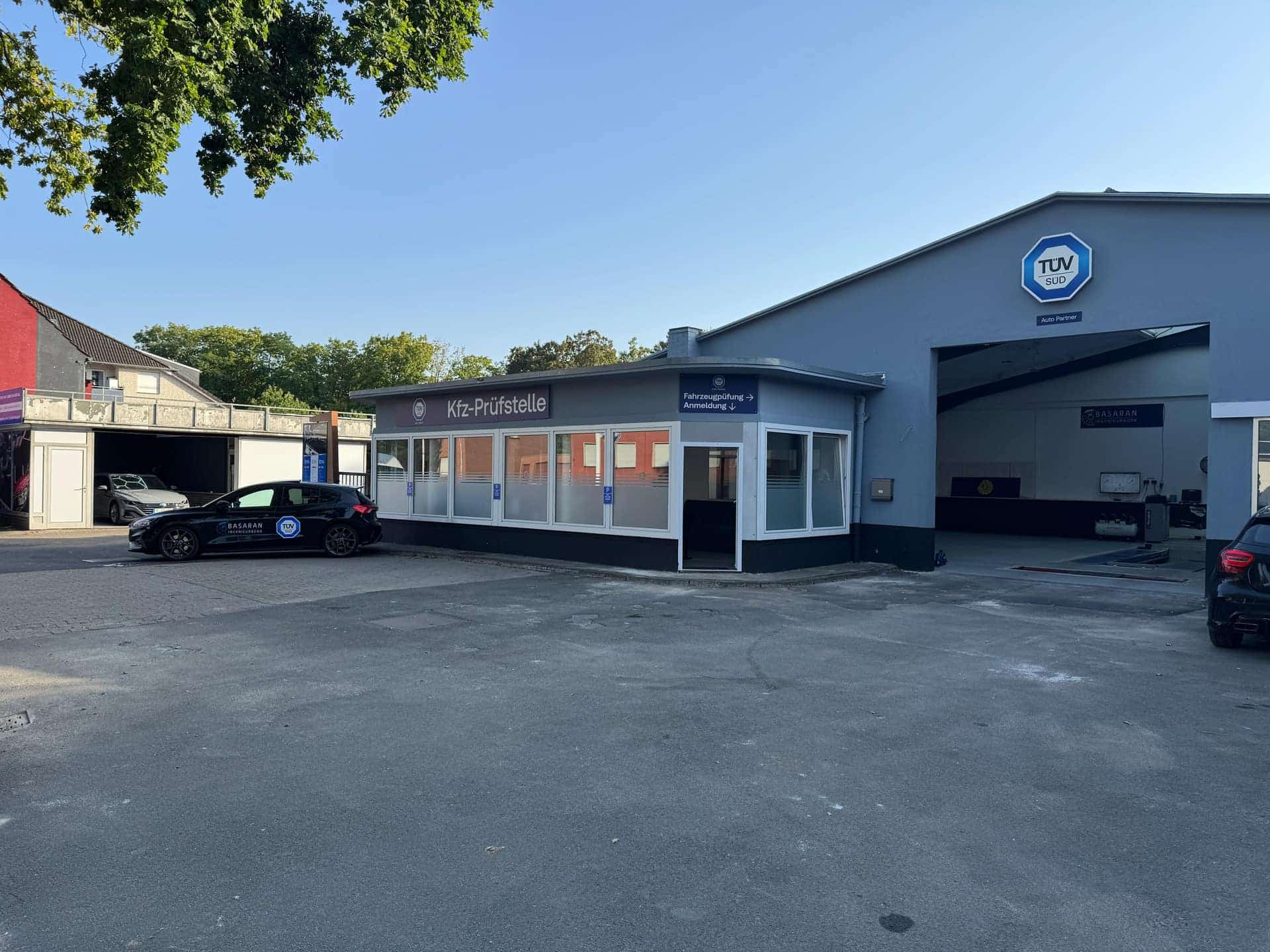 Außenansicht der Kfz-Prüfstelle Basaran in Ahlen mit TÜV-SÜD-Schild über der Prüfhalle